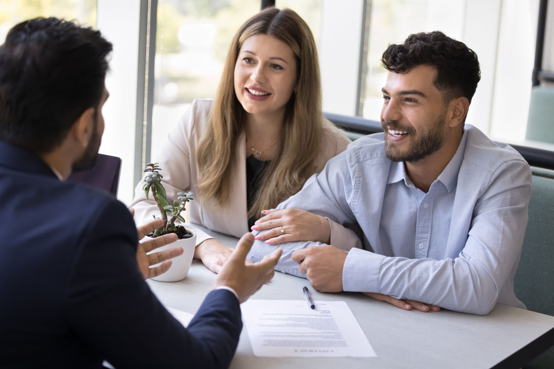Happy young diverse husband and wife consulting legal adviser